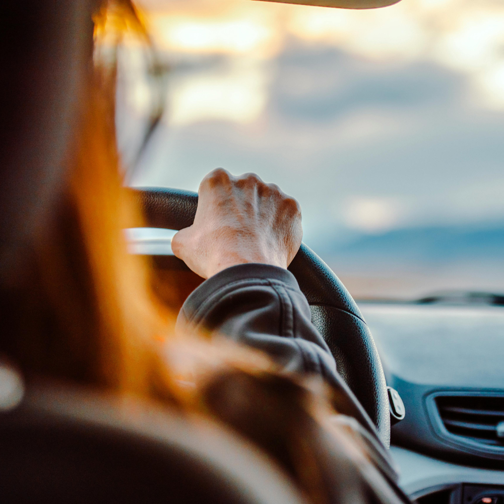 Person driving a car with a scenic view outside