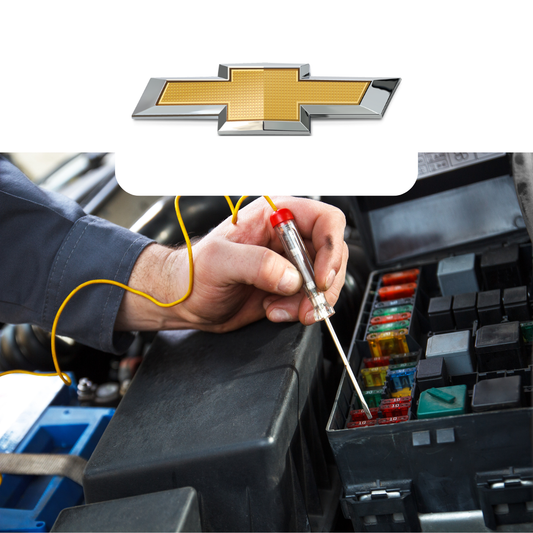 Person working on a car's fuse box with a Chevrolet logo above