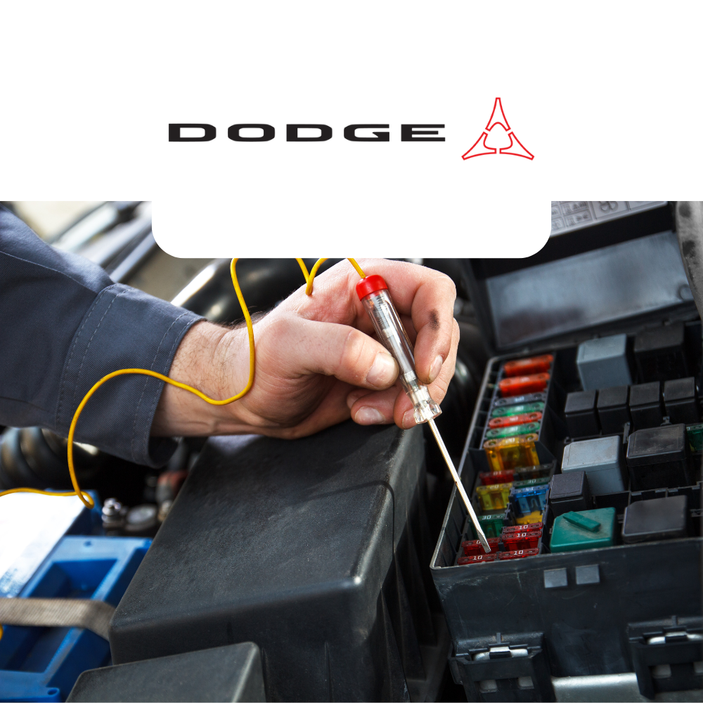 Person working on a car's fuse box with a Dodge logo above