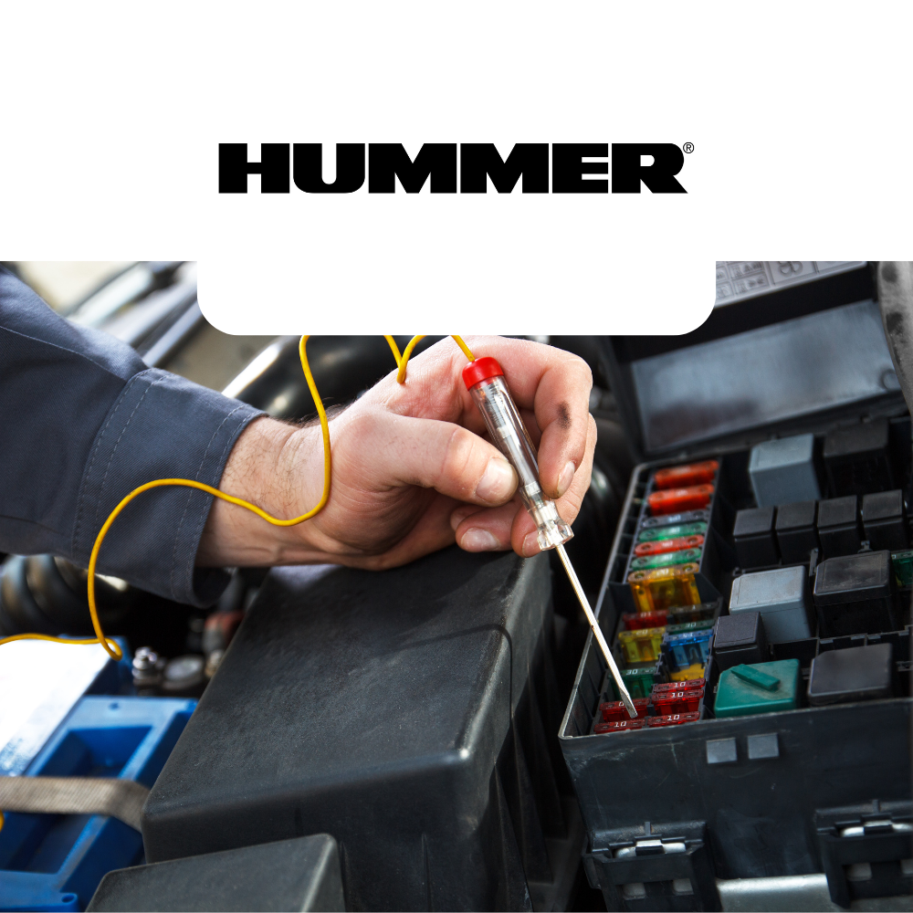 Person working on a car's fuse box with a 'Hummer' logo above