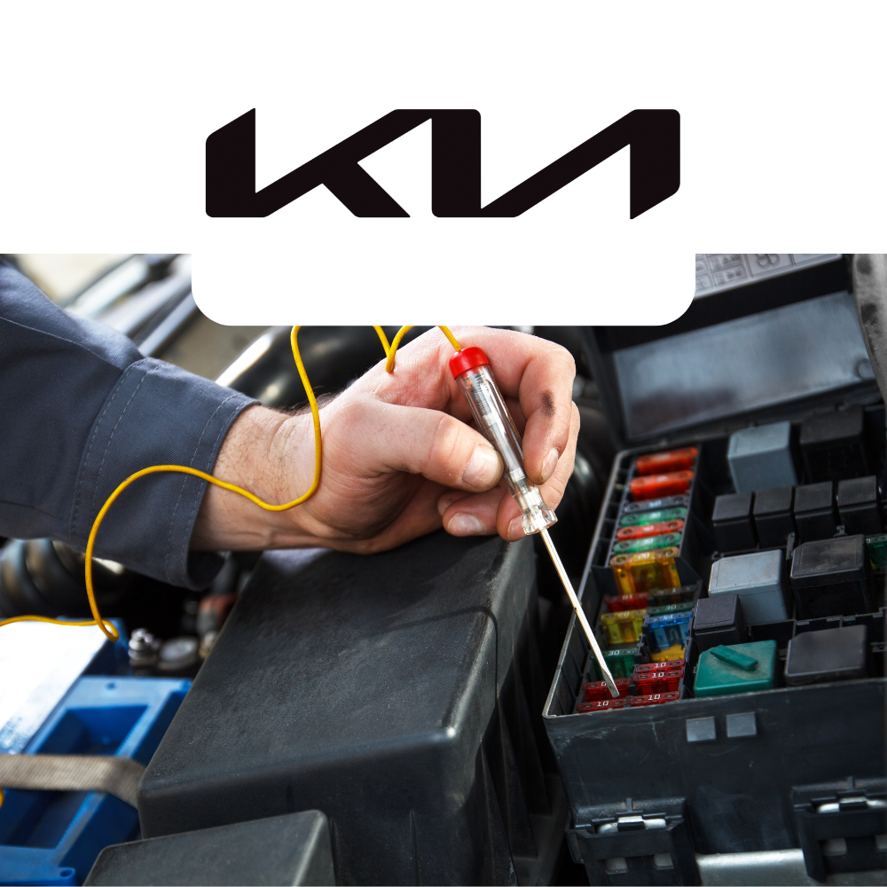 Person working on a car's fuse box with a KIA logo above