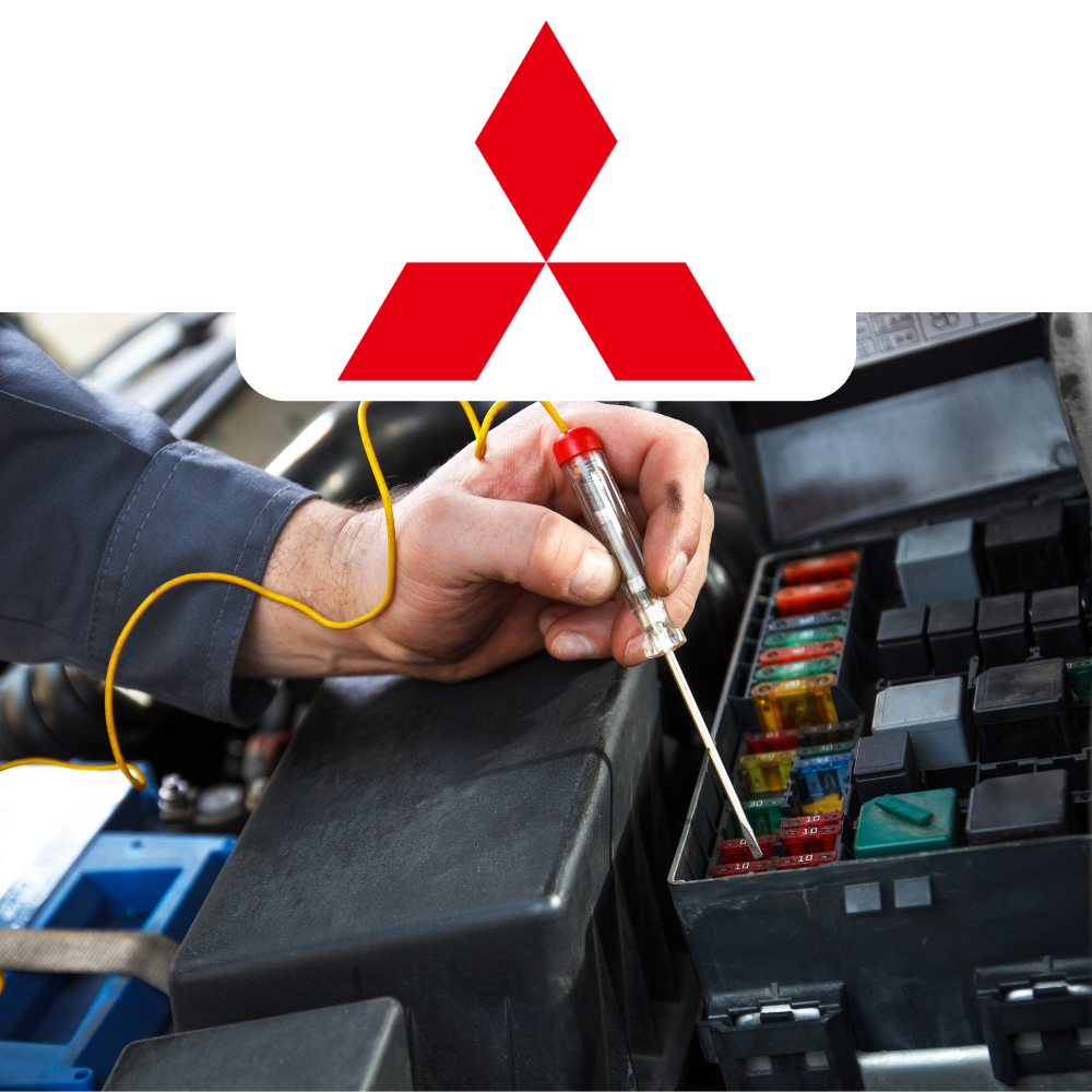 Person working on a car's fuse box with a Mitsubishi logo above